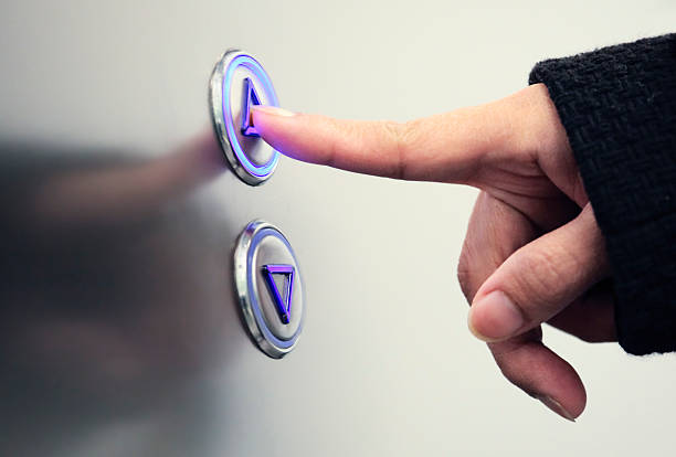 Person pushing up arrow elevator button.